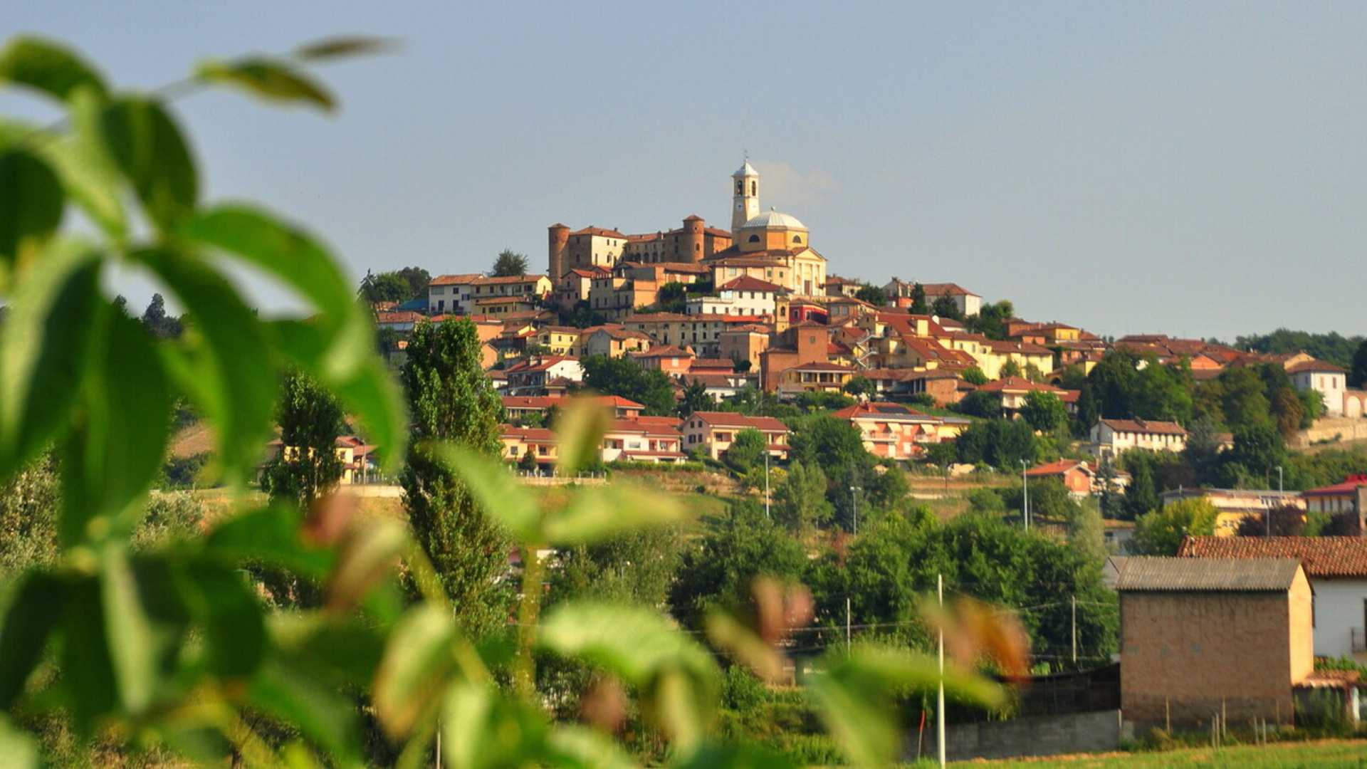 Panorama di un suggestivo borgo emiliano immerso nella natura, con strade acciottolate e case storiche.